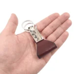 جاکلیدی چرمی مدل 2 حلقه رنگ مشکی با چرم پهن روی کف دست با پس زمینه سفید