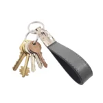 جاکلیدی چرمی مدل 2 حلقه رنگ طوسی همراه با کلید با پس زمبنه سفید