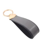 جاکلیدی چرمی مدل بیضی رنگ طوسی با پس زمینه سفید