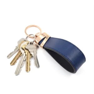 جاکلیدی چرمی مدل لبخند رنگ سرمه ای همراه با کلید با پس زمبنه سفید