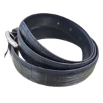 کمربند چرمی رنگ مشکی طرح کروکدیلی با سگک نقره ای که به صورت گرد شده کمی با زاویه بیرون زدگی روی پس زمینه سفید هستش