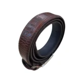 کمربند چرمی رنگ قهوه ای طرح کروکدیلی با سگک نقره ای که به صورت حلقوی ایستاده روی پس زمینه سفید هستش