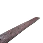 نمای نزدیک از کمربند چرم مردانه رنگ قهوه ای طرح کروکدیلی با سگک نقره ای روی پس زمینه سفید