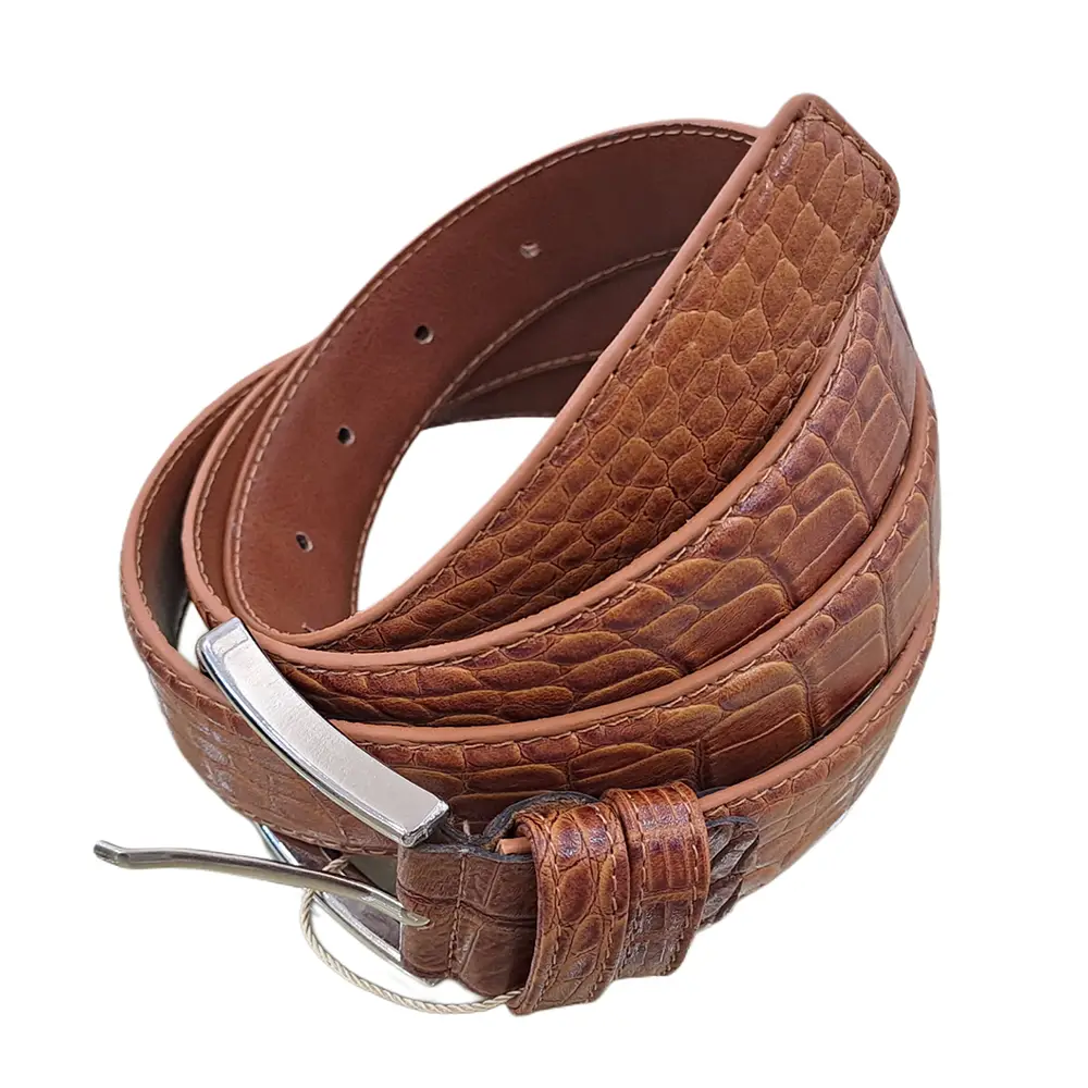 کمربند چرمی رنگ عسلی طرح کروکدیلی با سگک نقره ای که به صورت گرد شده کمی با زاویه بیرون زدگی روی پس زمینه سفید هستش