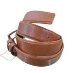 کمربند چرمی رنگ عسلی طرح فلوتر با سگک نقره ای که به صورت گرد شده کمی با زاویه بیرون زدگی روی پس زمینه سفید هستش